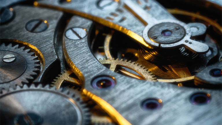 Close-up view of interlocking metal gears and cogs, showing the precision and craftsmanship that reflect themes of manufacturing innovation.