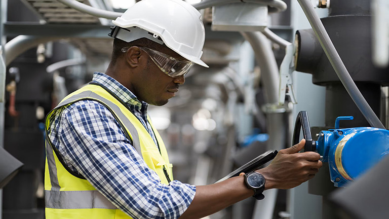 Engineer in a hard hat checking equipment